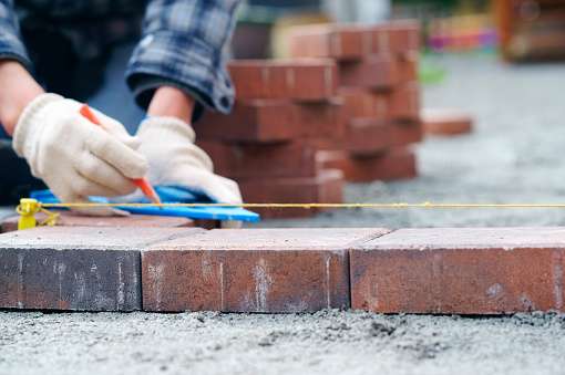 Laying gray concrete paving slabs in house and tools